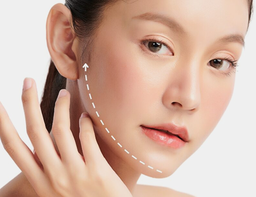 A close-up image of a female model with a focus on facial contouring, showcasing her hand gently touching her face.
