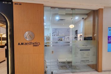 The entrance of A.M Aesthetics clinic showcasing the logo and a modern interior.