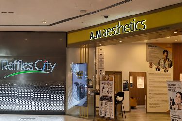 An entrance to A.M aesthetics located in Raffles City, showcasing the modern signage and welcoming atmosphere.