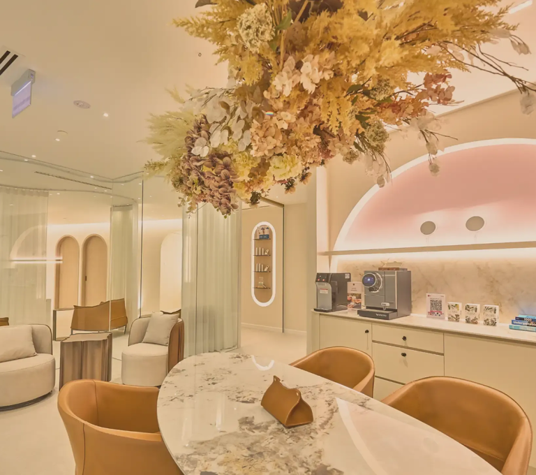A stylish interior view of a modern clinic featuring elegant furnishings and decorative floral arrangements.