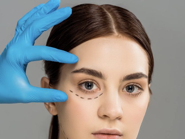 A healthcare professional indicating a surgical marking on a woman's face during a cosmetic procedure.