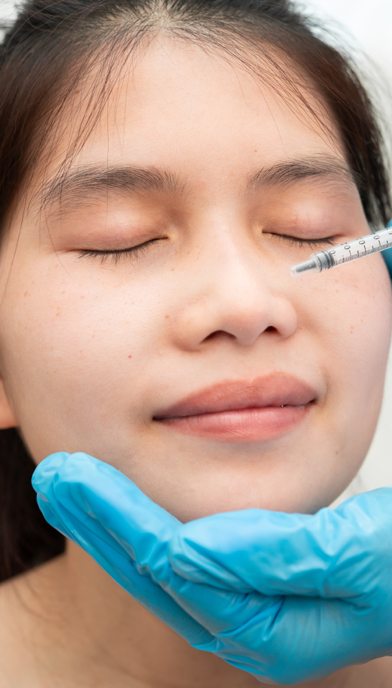 A close-up image showing a medical professional preparing to perform an under-eye filler treatment.